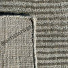 A close-up of a stylish rug with parallel waves in soothing colors